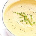 a white bowl filled with soup and garnished with parsley on the side