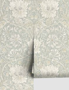 a wallpaper with white flowers and leaves on it's side, next to a gray background