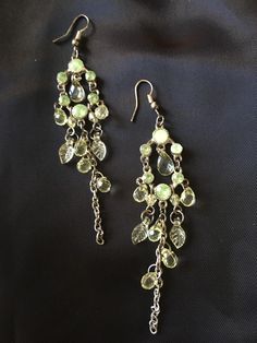 clear colored peridot dangling earrings Green Drop Crystal Earrings For Party, Green Pierced Chandelier Earrings For Party, Green Chandelier Pierced Earrings For Party, Green Jeweled Teardrop Earrings, Green Crystal Drop Earrings With Dangling Beads, Green Dangling Bead Chandelier Earrings, Green Dangle Jewelry With Dangling Charms, Green Dangle Jewelry With Charms, Jeweled Dangle Chandelier Earrings