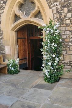 an entrance to a building with flowers growing out of it