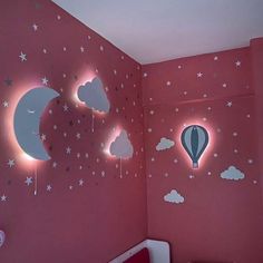 a child's room decorated in pink with stars and hot air balloons on the wall