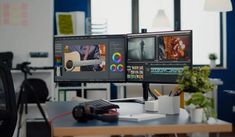 two computer monitors sitting on top of a desk