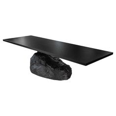 a black table with a rock on it's base and an animal head at the top