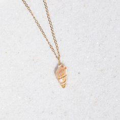 Description: This dainty seashell necklace features a tiny conch shell delicately wrapped in golden wire. Length: 18 inches Materials: Handcrafted using a genuine shell, non-tarnish golden lacquered copper wire, and stainless steel chain. Dainty Shell Charm Necklace For Beach, Wire Wrapped Shell Necklace For Beach, Gold Wire-wrapped Necklaces For The Beach, Gold Wire Wrapped Necklace For The Beach, Wire Wrapped Shell Necklaces In Shell Shape, Wire Wrapped Shell Necklaces, Dainty Gold Shell Jewelry, Wire Wrapped Shell Necklace Gift, Gold Wire Wrapped Shell Necklace