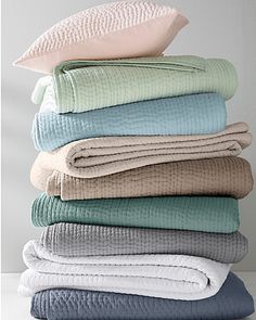 a stack of folded towels and blankets on top of each other