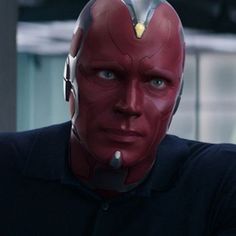 a close up of a person wearing a red mask and looking off to the side