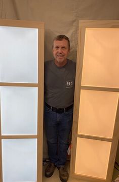 a man standing in between two tall doors