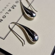 The silver liquid metal effect that gives them the appearance of a fresh raindrop is a unique and elegant that is sure to catch the eye. The contemporary design of the earrings with a teardrop shape and fixed hook drop setting makes them easy and fuss-free to wear, which is always a plus. The polished finish adds to their sleek and modern look, while the silver liquid metal effect gives them an organic and natural feel. these Sterling Silver liquid Drop Earrings are a beautiful and sophisticated Modern Metal Drop Earrings For Pierced Ears, Formal Metal Teardrop Drop Earrings, Modern Metal Drop Teardrop Earrings, Modern Metal Teardrop Drop Earrings, Modern Teardrop Drop Earrings For Everyday, Modern Silver Teardrop Earrings, Modern Silver Teardrop Pendant, Silver Teardrop Earrings With Polished Finish For Gift, Elegant Silver Water Drop Earrings