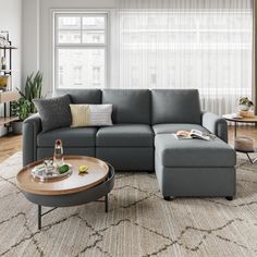 a living room with a sectional couch and coffee table in front of a large window