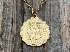 Gorgeous shiny gold, antique replica, of the Twin Hearts (Sacred Heart of Jesus and Immaculate Heart of Mary Medal) dangles from a textured 3 x 1.5 mm cable chain with a lobster clasp closure. Beautiful details! This fine replica is cast in solid gold bronze using the lost wax method and produced in the U.S.A. Gold bronze does require periodic polishing using a cloth, but will stay gold. A polishing cloth is included. The medal is just under 1 inch. If you would prefer a different length chain, Gold Symbolic Necklace With Vintage Charm, Gold Spiritual Charm Necklace For Valentine's Day, Gold Spiritual Charm Necklaces For Valentine's Day, Spiritual Gold Charm Necklaces For Valentine's Day, Gold Necklaces With Antique Finish For Anniversary, Antique Finish Gold Necklace For Anniversary, Anniversary Gold Necklace With Antique Finish, Antique Gold Charm Necklace Nickel Free, Nickel-free Gold Heart Necklace For Anniversary