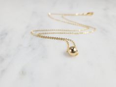 Add a touch of elegance with this simple delicate necklace featuring a dainty Gold Filled Ball floating on a chain. This simple floating necklace is the perfect finishing piece to any outfit. Wear it alone or layered with other necklaces. A great everyday necklace to add to your collection. The gold ball on this necklace is mobile and moves around the chain, turning it into the perfect dainty fidget necklace. Makes a great gift to add to any gemstone lover's collection. Perfect to gift for Chris Classic Drop Necklace With Adjustable Chain As Gift, Classic Drop Necklace With Adjustable Chain For Gifts, Simple Charm Necklace With Round Pendant And Delicate Chain, Dainty Round Pendant Necklace For Formal Occasions, Minimalist Clavicle Chain Charm Necklace For Formal Occasions, Minimalist Formal Charm Necklace With Clavicle Style, Minimalist Delicate Chain Necklace For Formal Occasions, Classic Drop Necklace With Round Pendant As Gift, Elegant Everyday Charm Necklace With Simple Design