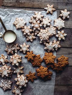 some cookies are sitting on a piece of paper next to a cup of milk and spoon