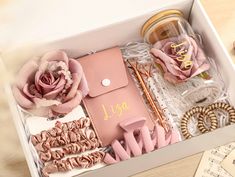 an open box with pink flowers and other items