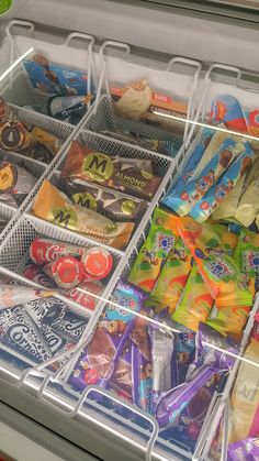 a refrigerator filled with lots of different types of candy and candies in bins