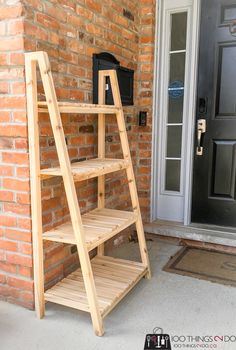 a wooden step ladder sitting on top of a brick wall next to a black door