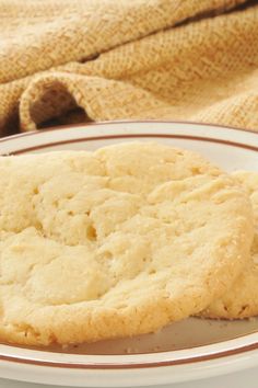 two cookies sitting on top of a white plate next to a brown and white towel