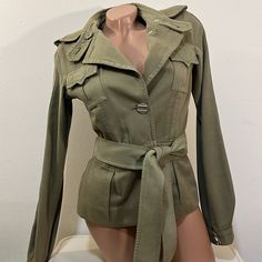 L.A.M.B. Military Style Long Sleeve Jacket Gwen Stefani Cotton And Wool Blend Buttoned Epaulettes Belt Loops Removable Belt Front Breast Pockets Buttons At Cuffs Soft Material Collar Front Buttons Darts At Waist Has Been Professionally Dry Cleaned Has Some Stains. See Pics Measurements Are Approximate Ptp 16” Waist 14 1/2” Length 24” Military Style Single Breasted Outerwear For Spring, Fitted Utility Jacket With Lapel Collar, Fitted Fall Outerwear With Belted Cuffs, Fitted Outerwear With Belted Cuffs For Fall, Military Utility Jacket With Lapel Collar For Fall, Fitted Button-up Outerwear With Belted Cuffs, Olive Long Sleeve Outerwear With Flap Pockets, Utility Long Sleeve Outerwear With Buckled Cuffs, Green Long Sleeve Outerwear With Belted Cuffs