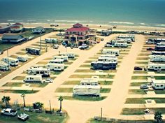 an aerial view of several recreational vehicles parked in a lot near the beach and ocean