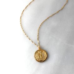 This gold pendant necklace is chic and stylish! A gold coin pendant graces a sparkling twist gold chain. Sure to be your favorite, this go with your favorite white tee or dressed too!•18kt gold over sterling silver coin pendant 22mm •A 14kt gold filled dainty singapore twist chain Gold Chain Coin Necklace As Gift, Gold Plated Coin Pendant Necklace, Gold Chain Coin Necklace Gift, Classic Gold Medallion Necklace With Coin Pendant, Classic Gold Coin Necklace With Round Pendant, Classic Gold Plated Coin Necklace With Round Pendant, Elegant Everyday Medallion Necklace Shaped Like A Coin, 14k Gold Filled Yellow Gold Coin Necklace, Gold Sterling Silver Coin Necklace With Round Pendant