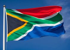 the flag of south africa flies high in the blue sky