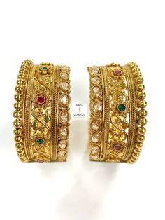 Elegant and traditional temple kada set in antique gold plating studded in champagne crystals, rubies and emerald stones. Very intricate floral design. Openable kada set in South Indian design. Size: Fits 2-4 and 2.6 very well. A little snug on 2.8. South Indian Design, Pearl Mala, Big Pearl, Emerald Stone, Indian Design, Intricate Design, Pearl Drop, Gold Jewellery, Gold Bangles