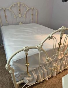 a white bed with an ornate headboard and foot board