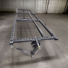 a metal frame sitting on top of a floor in a warehouse or office building with no one around it