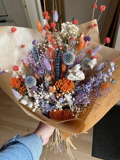 a person holding a bouquet of flowers in their hand