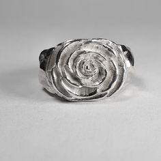 **Please note that we dispatch on Tuesdays unless special delivery express option is paid for** Sterling silver Camellia ring. Original design carved in wax then lost wax cast into solid sterling silver.  Piece weighs approximately 17g.  Shown in a size N, and adjustable to ring sizes I-S.  A significant size adjustment may alter the appearance slightly.  First class post included, with a supplement for special delivery. Sterling Silver Carved Promise Ring, Hand Cast Sterling Silver Engraved Ring For Wedding, Silver Carved Signet Ring Gift, Carved Sterling Silver Rings For Anniversary, Silver Hand Cast Engraved Ring For Promise, Hand Cast Silver Rings For Anniversary, Anniversary Sterling Silver Carved Rings, Anniversary Carved Sterling Silver Ring, Unique Hand Cast Signet Ring For Anniversary