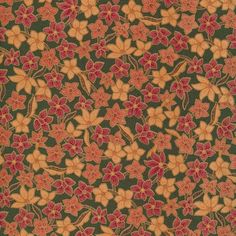 an orange and red flowered pattern on green fabric with pink flowers in the center