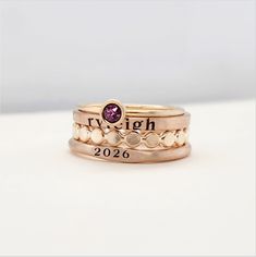 This 14k gold filled signet class ring set is the perfect gift for her, especially for graduation. Handmade and personalized, it adds a unique touch to any outfit. Elevate your style with this elegant and timeless piece. Included in this set is one 14k gold filled 4mm birthstone ring, one 14k gold filled signet ring personalized with a year, one 2mm 14k gold filled personalized name ring, and one 14k gold filled flat beaded ring. This ring set will be engraved in our lowercase serif font and is Gold Stackable Signet Ring For Gift, Hand Stamped 14k Gold Engraved Ring, 14k Yellow Gold Hand Stamped Engraved Ring, 14k Yellow Gold Engraved Ring With Hand Stamped Details, Hand Stamped 14k Yellow Gold Engraved Ring, Gold Signet Ring With Birthstone In 14k Gold, Heirloom Rose Gold Stackable Rings Stamped 14k, Classic 14k Gold Filled Stackable Rings Gift, Classic Rose Gold Engraved Stackable Ring