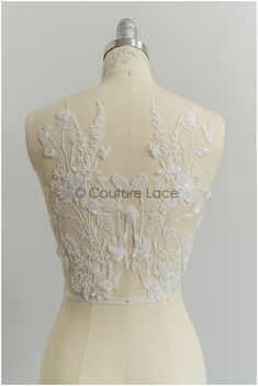 the back of a dress with white flowers on it