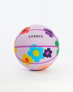 a pink ball with flowers painted on it that says,'chance'in black lettering