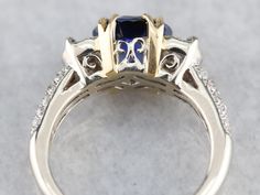 This sapphire is one of the finest gemstones currently found in our collection, and incredible fine gem that is filled with fire! The perfect shade of Cornflower, this gorgeous sapphire has flashes of violet and cobalt radiating from its center. Modern in manufacture, this opulent ring has a Renaissance feel, thanks to the European style split prongs, cast in lush yellow gold. The richness of these secure prongs creates a perfect contrasting frame for the sapphire at the center, while the perfec Luxury Sapphire Gemstones With Multiple Stones, Luxury Sapphire Gemstones With Gemstone Accents, Luxury Sapphire Gemstones With Accent Stones, Luxury Trillion-cut Sapphire Ring, Luxury White Gold Sapphire Ring With Gemstone Accents, Fine Jewelry Polished Sapphire Ring, Luxury Trillion Cut Sapphire Ring With Center Stone, Luxury Sapphire Ring With Trillion Cut, Luxury Polished Lab-created Sapphire Ring