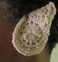 a close up of a person wearing a crochet ear warmer