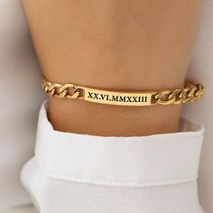 Introducing our stunning 18k Gold-Plated Engraved Bracelet, a timeless piece that effortlessly combines elegance with personalization. Perfect for both men and women, this sleek wrist bracelet features a band of 18k gold-plated stainless steel, ensuring it not only looks luxurious but also stands the test of time. At its center, a plate engraved with Roman numerals allows you to commemorate a special date, making it a unique and meaningful accessory. Crafted with meticulous attention to detail, Adjustable 14k Gold Bracelet, Classic Gold Bracelet With Engraving Option, Classic Engraved Bracelets For Gifts, Gold-tone Jewelry Bracelet Strap For Gift, Gold-tone Stainless Steel Chain Bracelet For Gifts, Personalized Gold-plated Bracelets For Anniversary, Elegant Stainless Steel Name Bracelet As A Gift, Personalized Gold Plated Bracelets For Anniversary, Classic Yellow Gold Bracelets With Engraving Option