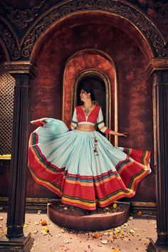 a woman in a colorful dress is posing for the camera