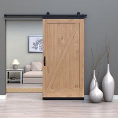 a living room with two vases on the floor and a sliding door in the middle