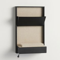 a black shelf with an open drawer on the side and a white wall behind it