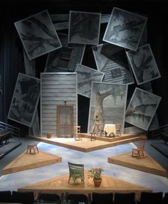 an empty stage with chairs and pictures on it