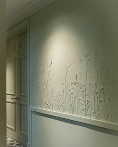 the wall is decorated with white flowers and plants on it's side, along with tile flooring