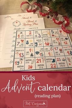 the kids's advent calendar reading plan with christmas decorations and ribbon around it, on top of a table