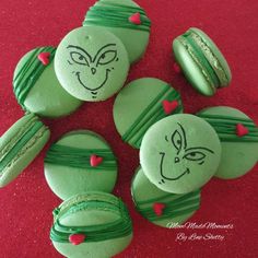 green macaroons with faces and hearts on them