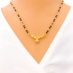 This Mangal Sutra, made with 22k yellow gold and weighing 8.3 grams, features a dazzling evergreen design. It's adorned with black beads, adding a classic touch to the piece. The necklace measures 16 inches in length with a drop of 0.3 inches, and it includes 0.6 inches of adjustable links for a customized fit. The hook lock ensures secure and comfortable wear. This Mangal Sutra is perfect for those who appreciate timeless elegance blended with a hint of modern allure. PRODUCT DETAILS Gold Purit Temple Style Necklaces With Black Beads For Festivals, Festive Temple Jewelry Necklace With Black Beads, Festival Temple Jewelry Necklace With Black Beads, Festive Black Round Beads Jewelry, Festive Black Round Beaded Jewelry, Festive Black Round Necklace, Festive Black Necklace, Black Round Beads Jewelry For Diwali, Festive Black Temple Jewelry Necklaces