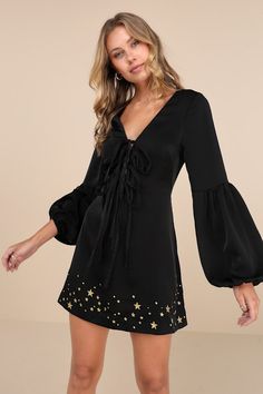 Put a twinkle in everyone's eye with a mysteriously sweet look like the Stoned Immaculate Wild One Black Star Embroidered Tie-Front Long Sleeve Mini Dress! Sleek satiny woven fabric shapes this too-cute dress with a flattering V-neckline, darted bodice with a tie-front design (with four tying bows), and long, seamed balloon sleeves with elasticized cuffs. The fit-and-flare silhouette finishes with an A-line skirt that boasts embroidered gold stars in varying sizes across the mini hem. Hidden bac Tying Bows, Dress With Flared Sleeves, Embroidered Tie, Black Embroidered Dress, Graduation Outfit, Wild One, Long Sleeve Mini, Black Star, Balloon Sleeves