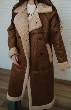 Yes, staying warm is essential - but so is looking cute! Notch rugged faux leather Teddy shearling Longline coat Side pockets 100% polyester Model is 5'3" and wearing a size small. The length of a size small is 42" with a 20" bust. Small: 2-4 Medium: 6-8 Large: 10-12 Fall Sheepskin Fur Coat With Fleece Lining, Fall Outerwear With Fleece Lining And Sheepskin, Fall Sheepskin Outerwear With Fleece Lining, Long Coat With Faux Fur Lining For Cold Weather, Cold Weather Long Coat With Faux Fur Lining, Brown Faux Fur Long Coat, Shearling Long Fur Coat For Cold Weather, Long Shearling Fur Coat For Cold Weather, Shearling Long Coat For Cold Weather