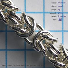 a close up of a metal chain on a piece of paper with words below it