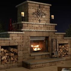 an outdoor fireplace is lit up at night