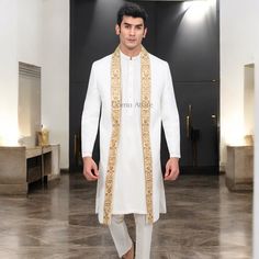 This luxury white open-front sherwani is a stunning choice for special occasions, combining elegance and traditional style. Features: Color: A pristine white, symbolizing purity and sophistication. Design: The open front adds a modern twist, allowing for a versatile look. Embellishment: Rich border embellishments adorn the sherwani, adding a touch of grandeur and intricacy. Fabric: Typically made from high-quality materials like silk or brocade, ensuring a luxurious feel. Fit: Tailored to provide a flattering silhouette, enhancing the wearer’s stature. Key Points: Occasions: Ideal for weddings, festive celebrations, or formal gatherings. Styling: Pairs beautifully with traditional kurta-pajama, enhancing the overall aesthetic. Layering: The open front allows for layering with different sty Prince Coat Shalwar Kameez, Traditional Kurta, Black Tuxedo Suit, Waistcoat Designs, Prince Coat, Sherwani Groom, Pajama Pattern, Blue Tuxedos, Groom Shoes