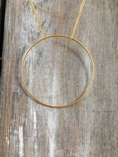 "Handmade necklace consisting of a large single circle strung from a delicate chain. The chain shown is 18\", but custom lengths are welcomed. Available in silver and gold. This unique necklace is perfect for anyone loves accessorizing with on trend, modern or minimalist jewelry. Made from high quality 16k gold plated brass. It has an effortless chic vibe to it and is great for layering. All jewelry is lovingly made in Massachusetts and ships profesionally packaged in an attractive box, ready to Gold Circle Necklace, Necklace Layering, Everyday Necklace, Geometric Necklace, Delicate Chain, Unique Necklace, Necklace Statement, Layering Necklace, Circle Necklace